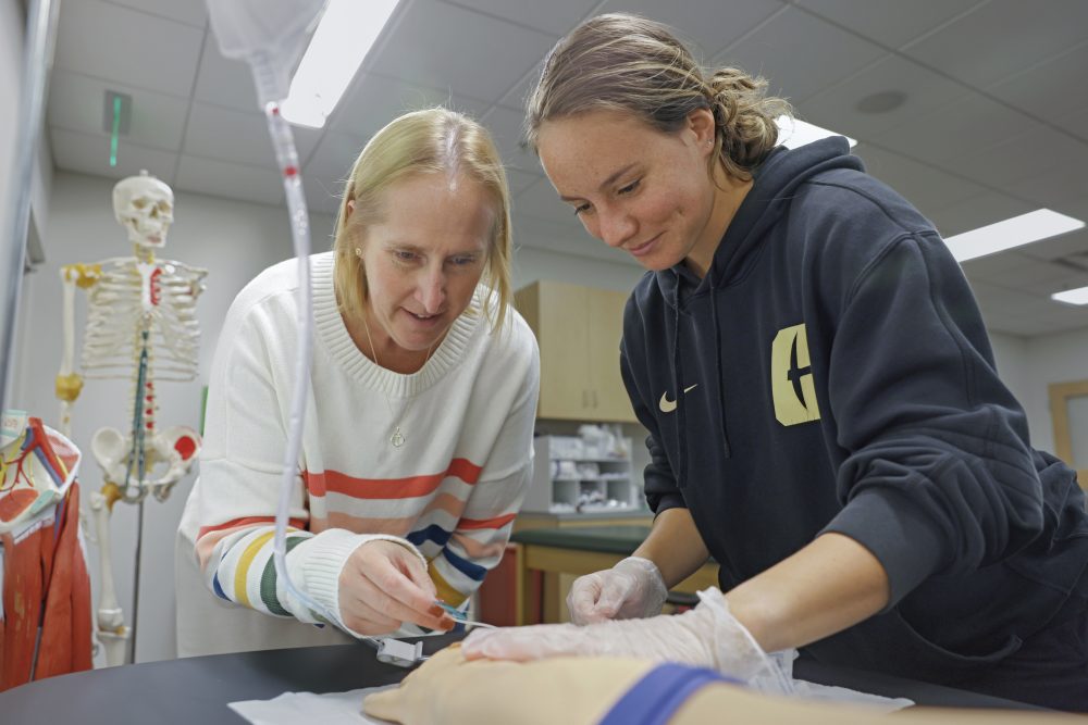 Professor teaches student how to insert and IV.