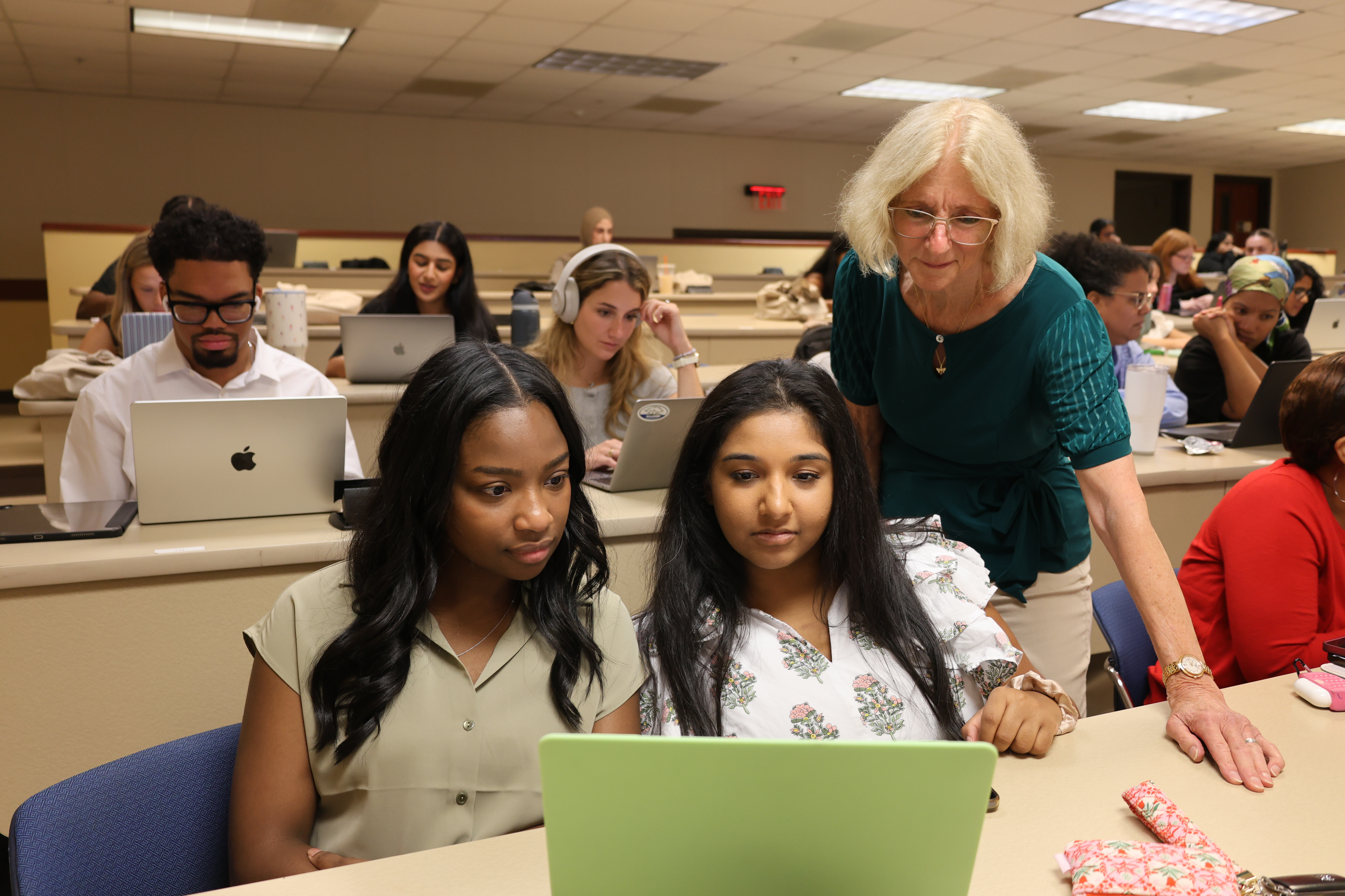 Teacher consulting with student in classroom